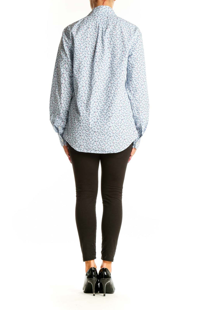 Side view of model wearing vineyard vines light blue floral print cotton shirt with black pants
