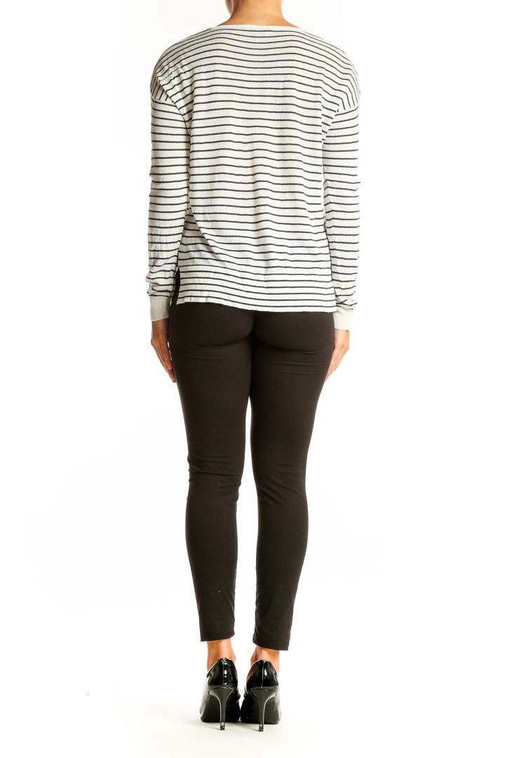 Side view of model wearing Pull & Bear White Striped Long Sleeve Knit Top with black pants