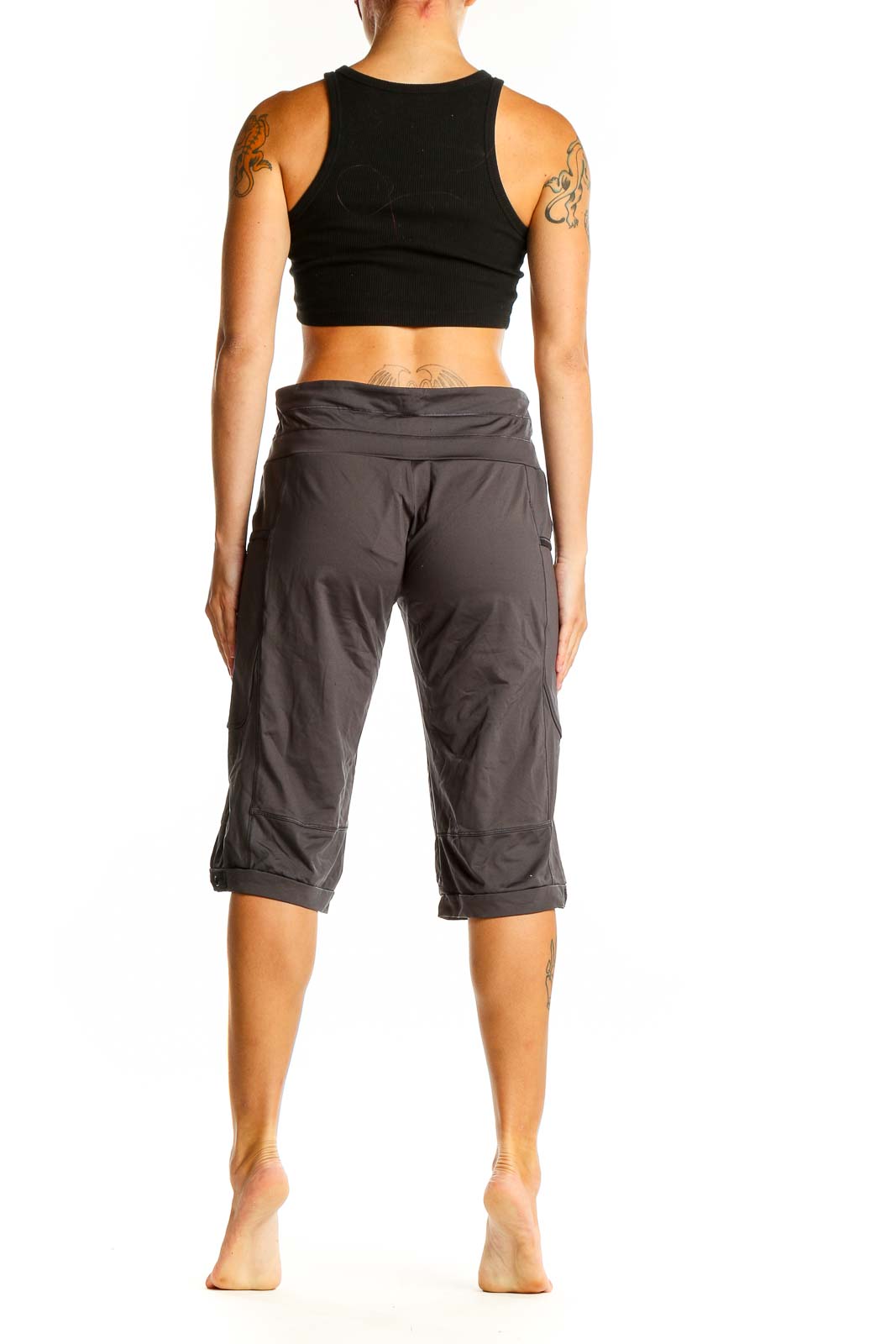 Side view of woman wearing gray Adidas activewear capri pants and black crop top