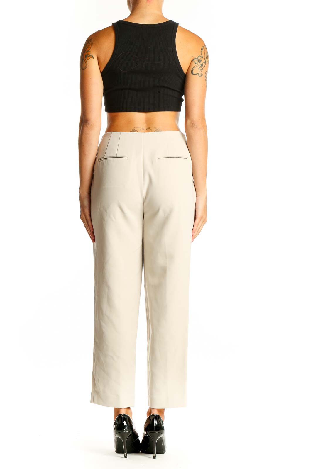 Side view of model wearing Ann Taylor beige tailored ankle-length trousers with black top