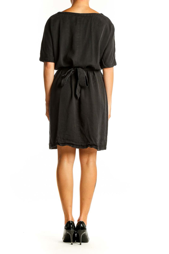 Side view of black RESERVED belted dress showing silhouette