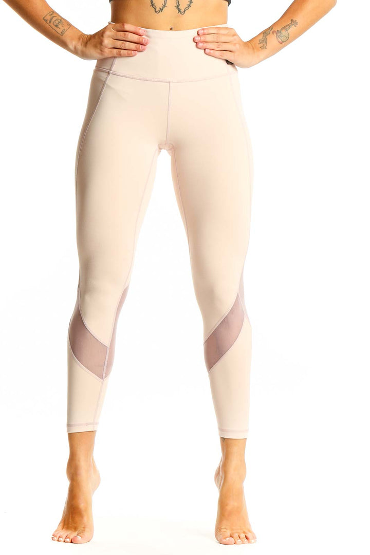 Front view of beige Athleta high-waisted leggings with mesh panels
