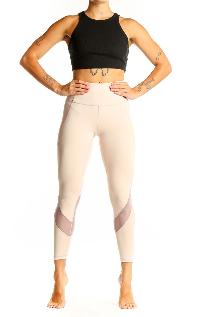 Front view of beige Athleta high-waisted leggings with mesh panels