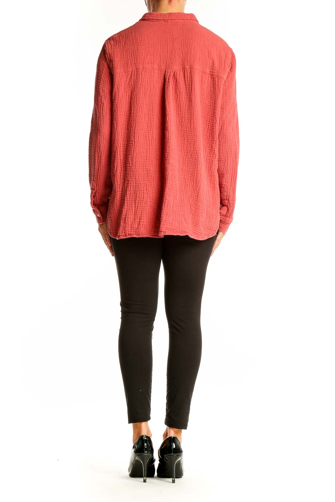 Side view of model wearing Jessica Simpson coral textured button-down shirt with black pants