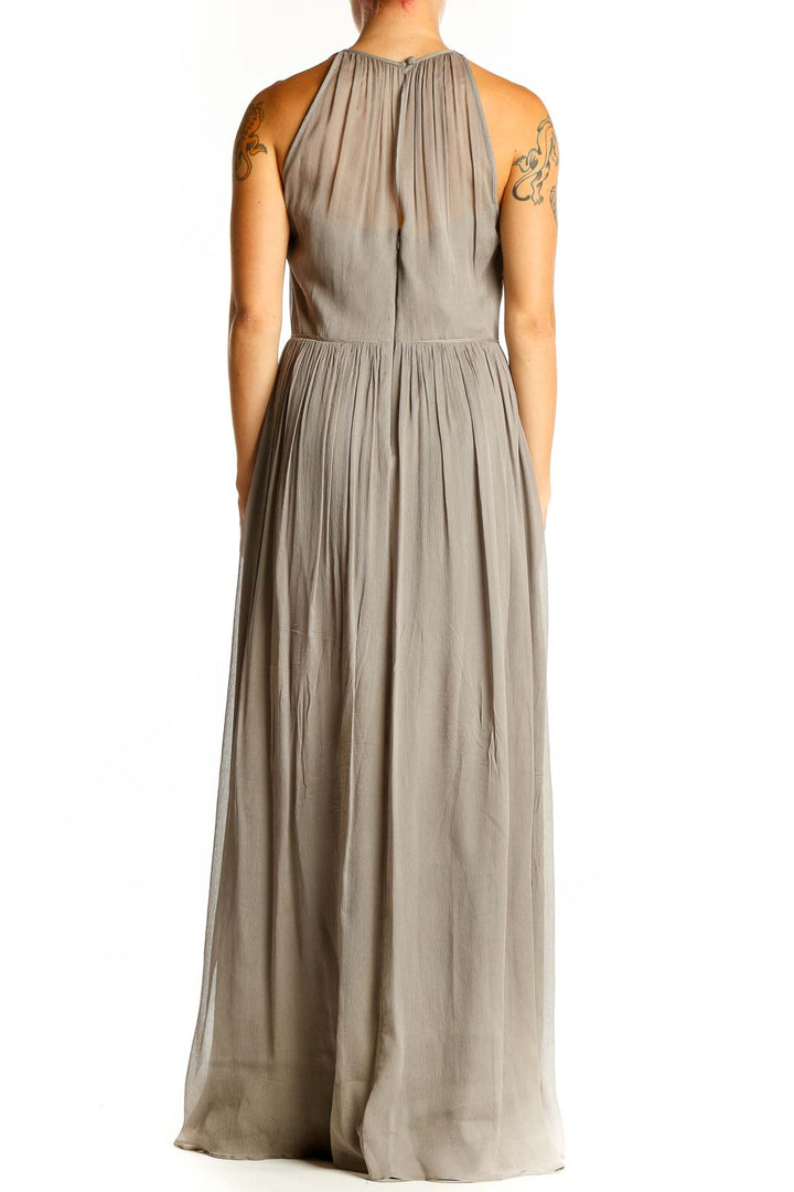 Back view of taupe J.Crew pleated chiffon maxi dress showing flowing silhouette