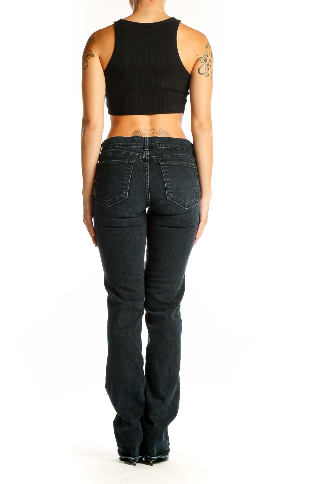 Side view of J Brand dark blue slim fit bootcut jeans on model