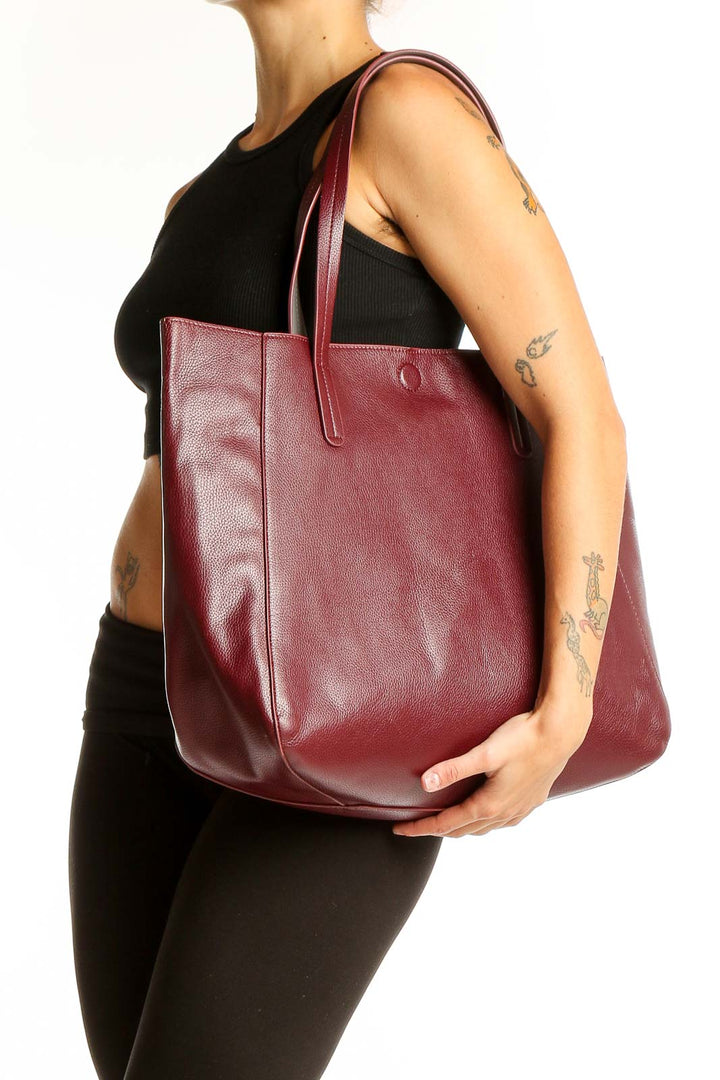 Front view of burgundy leather tote bag with long handles