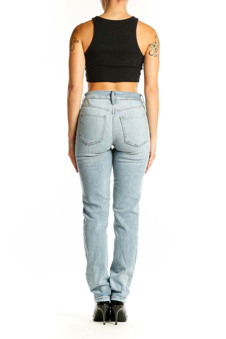 Side view of Banana Republic light blue distressed straight leg jeans on model with black crop top