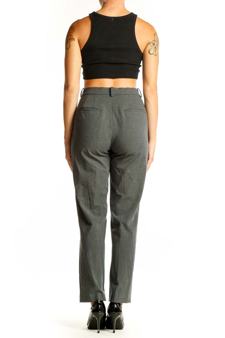 Side view of gray Uniqlo suit separates trousers on model with black crop top