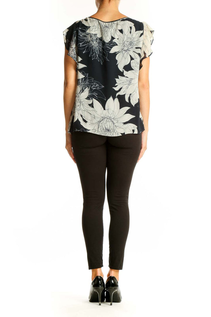 Side view of Vince Camuto black and white floral print blouse showing flutter sleeve detail