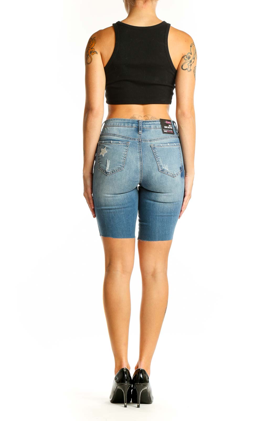 Side view of model wearing RAMPAGE light blue denim Bermuda shorts with black crop top