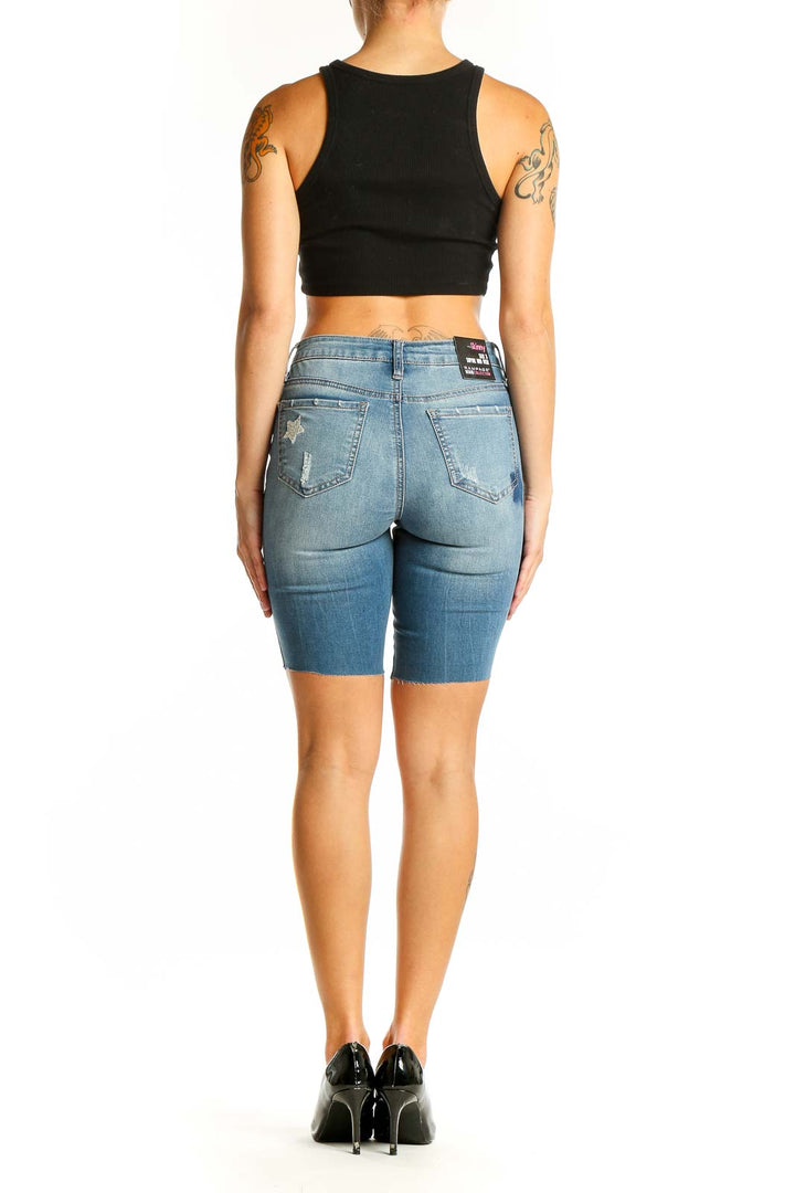 Side view of model wearing RAMPAGE light blue denim Bermuda shorts with black crop top