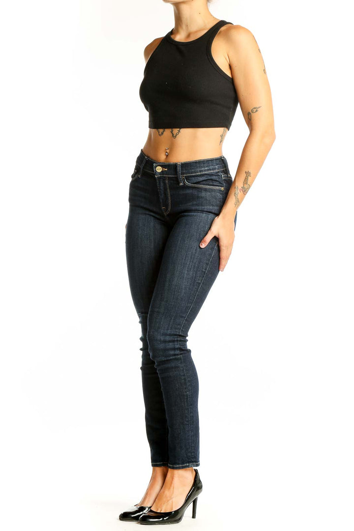 Front view of dark blue FRAME Denim skinny jeans on model