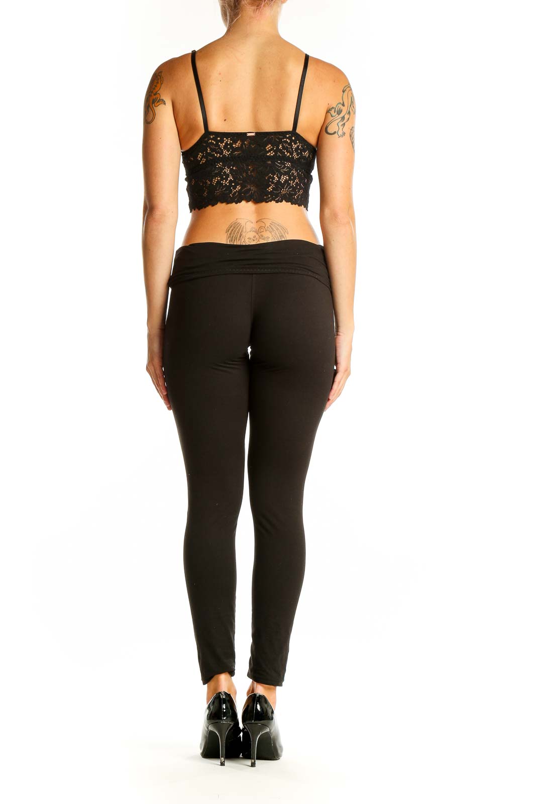 Side view of model wearing black lace crop top with black pants