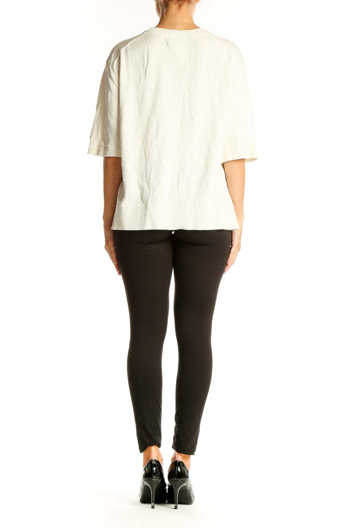 Side view of cream oversized short-sleeve knit top from Banana Republic on model