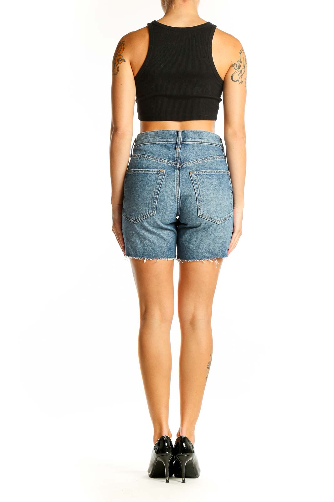 Back view of Gap blue distressed denim shorts on model with black crop top