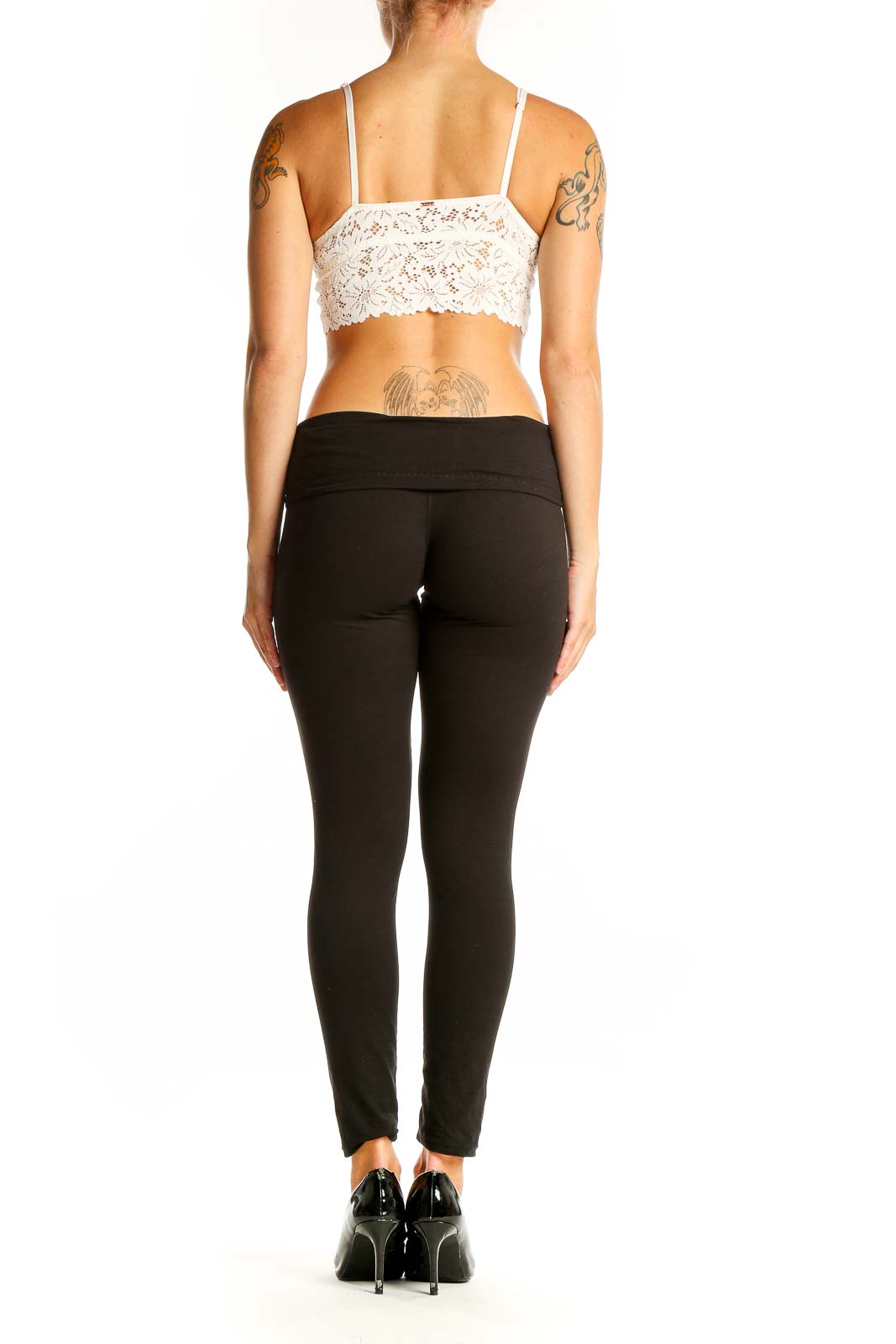Side view of model wearing white lace crop top bralette with black pants