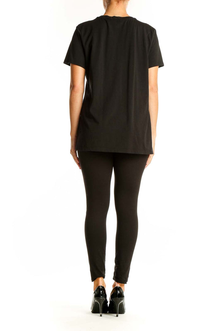 Side view of woman wearing black Calvin Klein t-shirt with animal print pocket