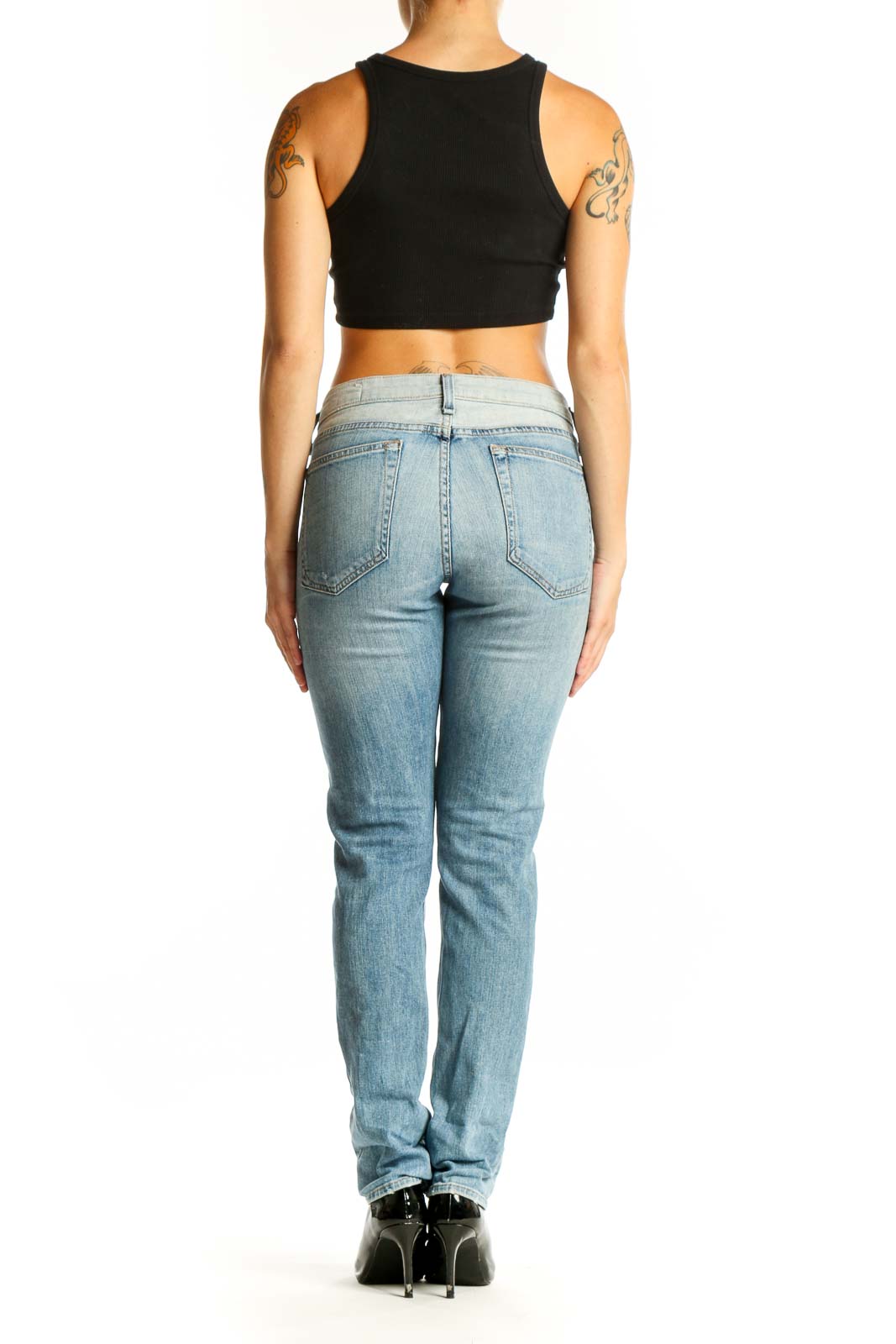Side view of woman wearing Rag & Bone light blue straight leg jeans with black crop top