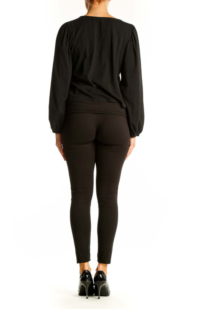 Side view of black Banana Republic ruched top paired with dark pants