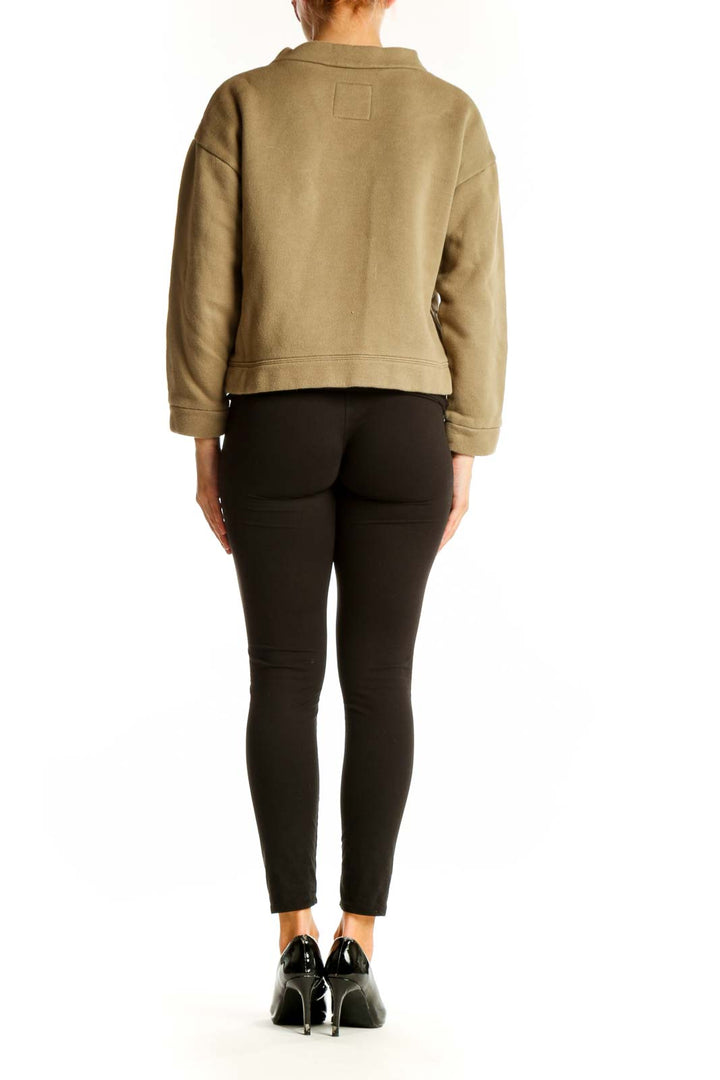 Side view of model wearing Madewell tan cropped mock neck sweatshirt with black pants