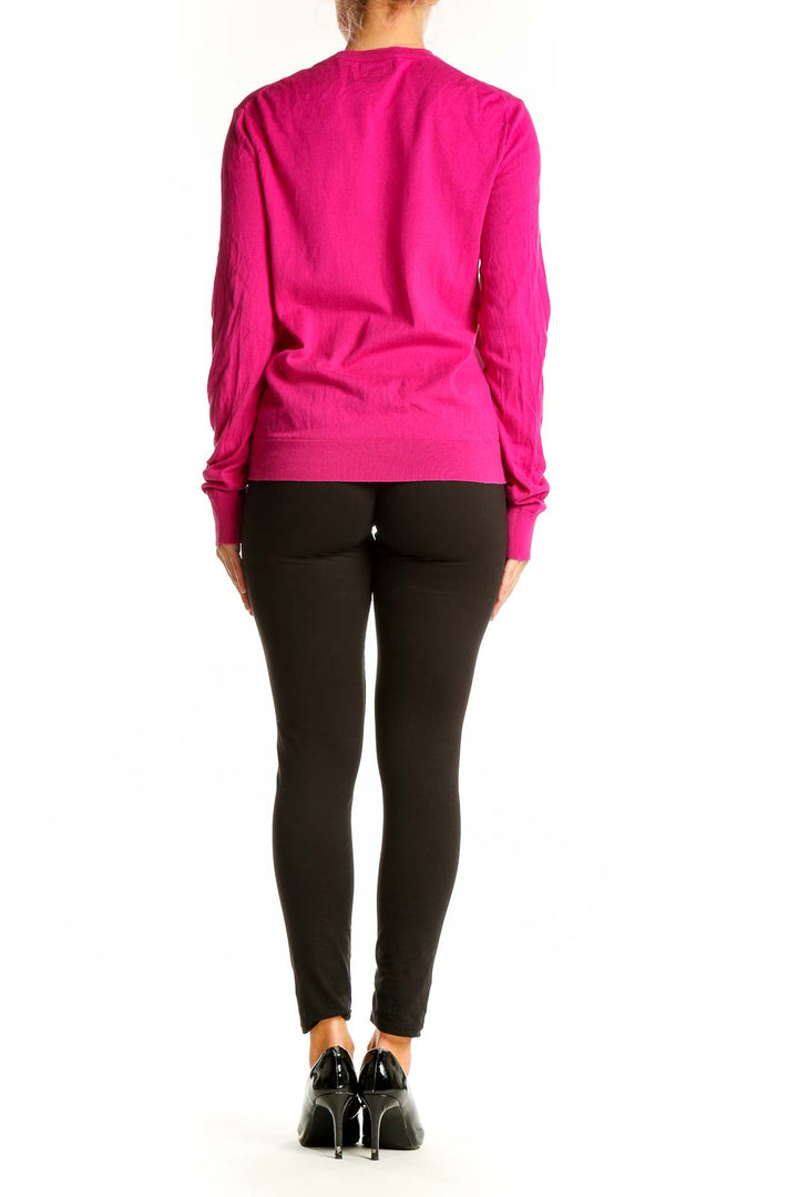 Side view of woman wearing hot pink J.Crew cotton cardigan with black pants