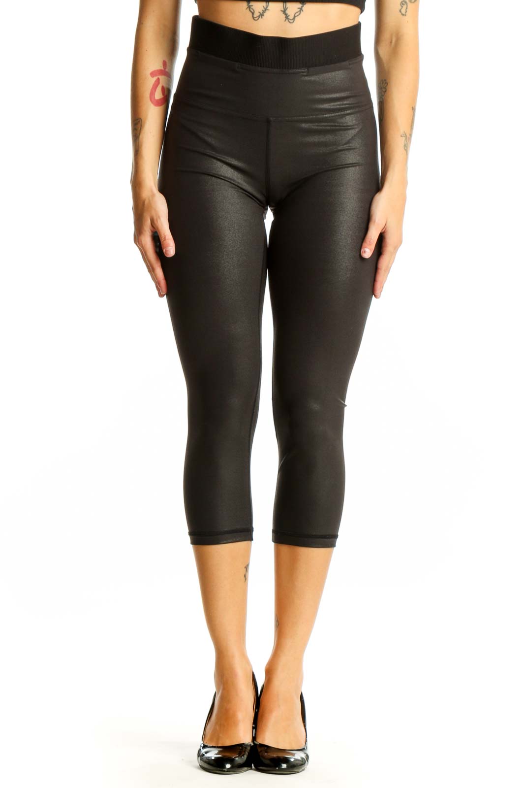 Front view of black shiny Lululemon capri leggings on model