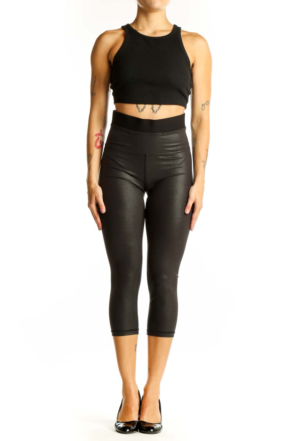 Front view of black shiny Lululemon capri leggings on model