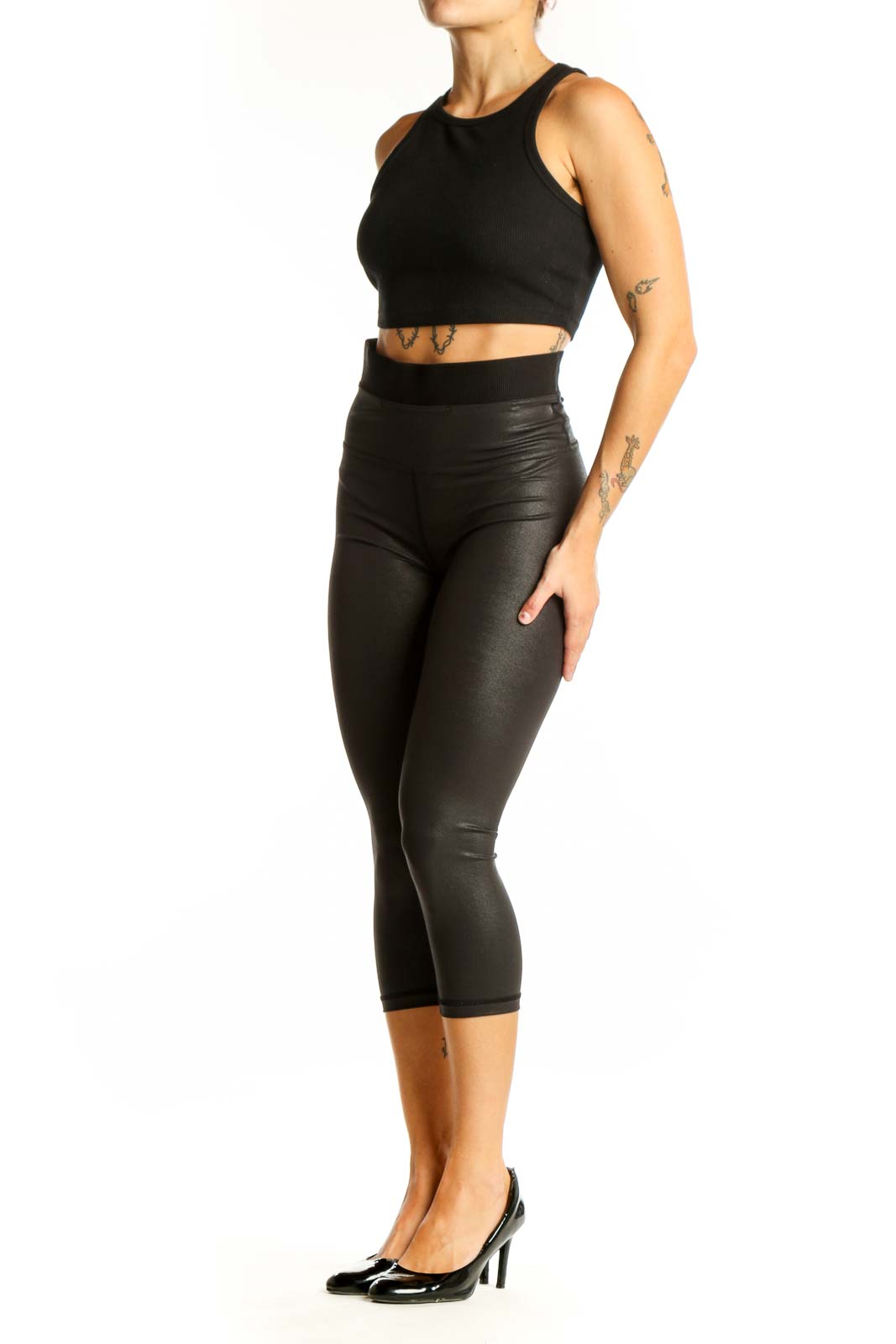Front view of black shiny Lululemon capri leggings on model