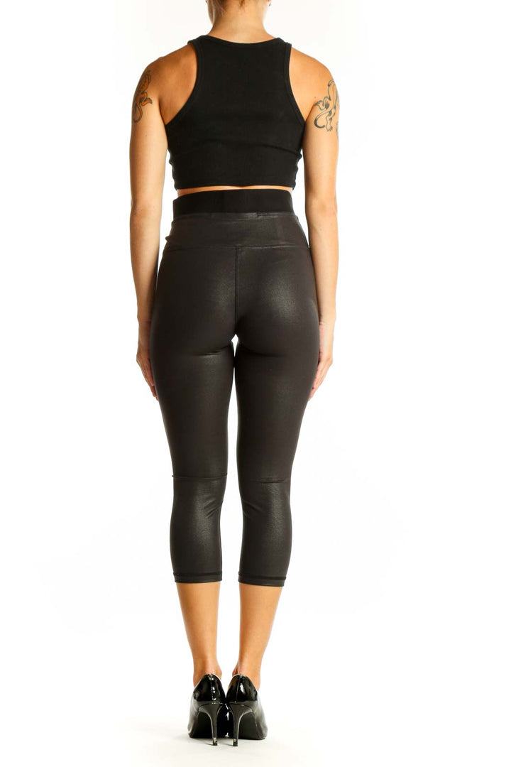 Side view of black shiny Lululemon capri leggings with matching crop top
