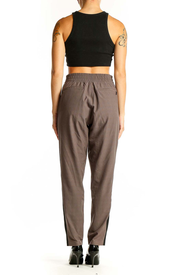 Side view of brown Athleta athletic pants showing contrasting stripe detail