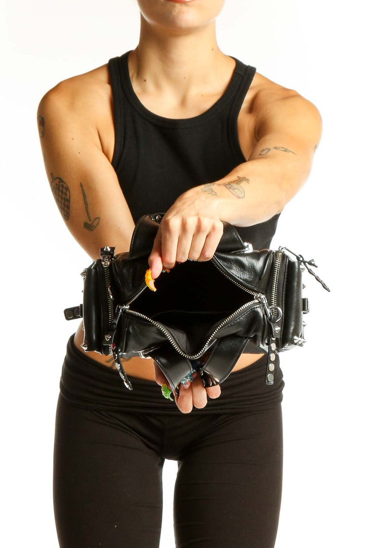 Side view of person wearing black MARC JACOBS studded shoulder bag