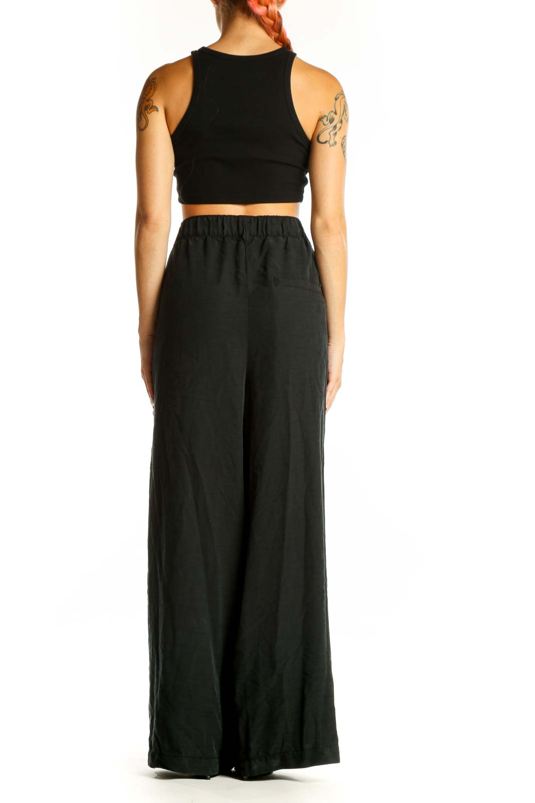 Side view of model wearing Free People black wide-leg pants with crop top