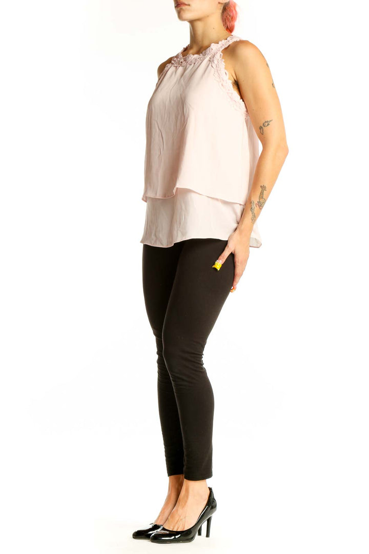 Front view of light pink layered sleeveless blouse with ruffle neckline