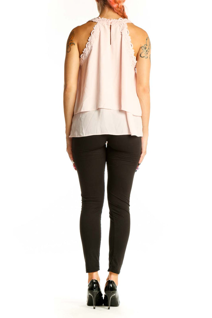 Side view of light pink layered sleeveless blouse on model