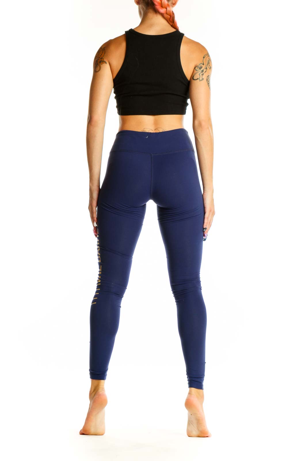 Side view of woman wearing navy Splits Fifty Nine leggings and black crop top