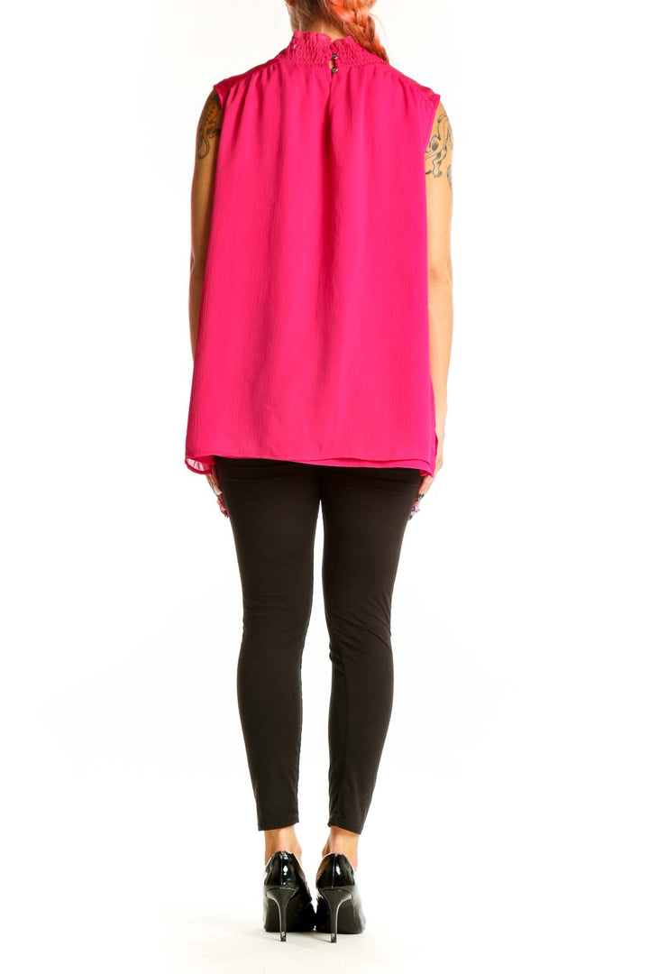 Back view of hot pink DKNY sleeveless mock neck blouse on model