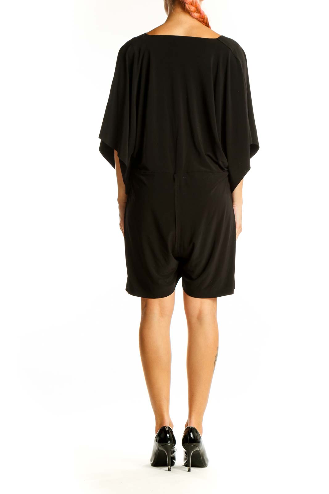 Side view of black NORMA KAMALI mini dress showing flowy silhouette