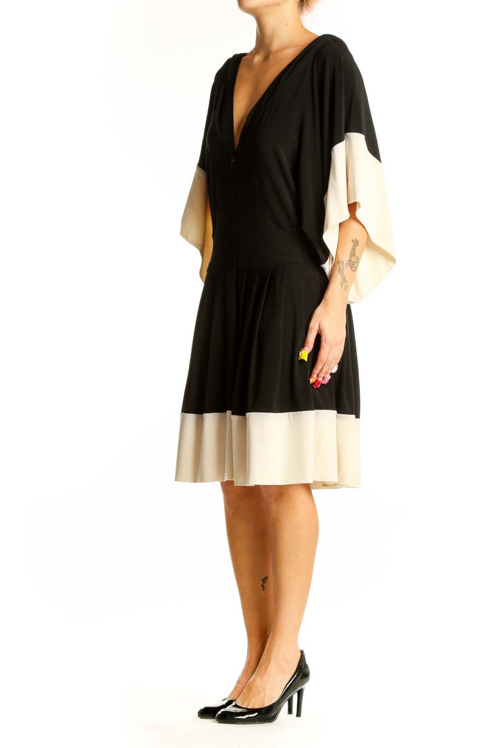 Front view of NORMA KAMALI black and cream color-block dress with V-neck and batwing sleeves