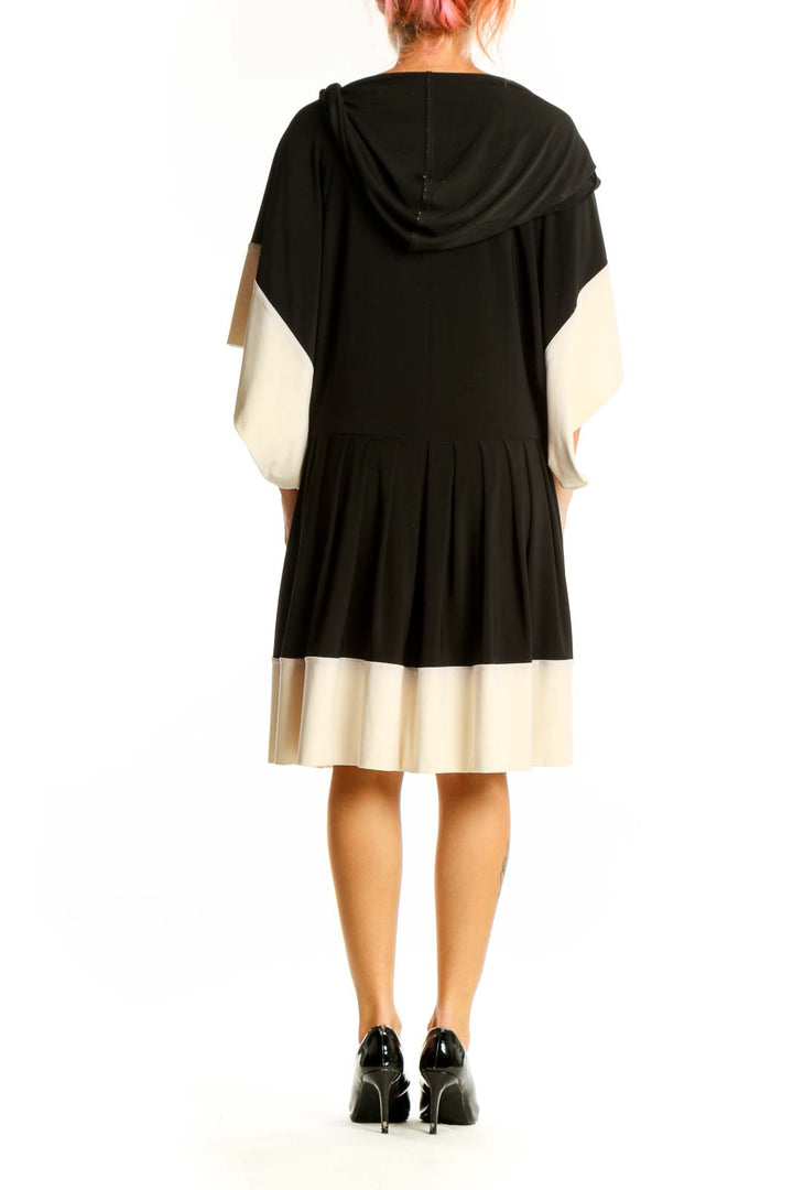 Side view of NORMA KAMALI black and cream color-block dress showing flowy silhouette