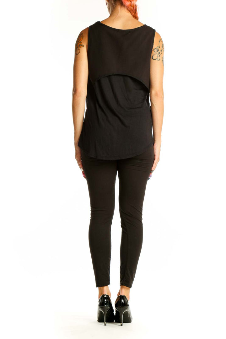 Side view of woman wearing black Harlowe & Graham tank top with black pants