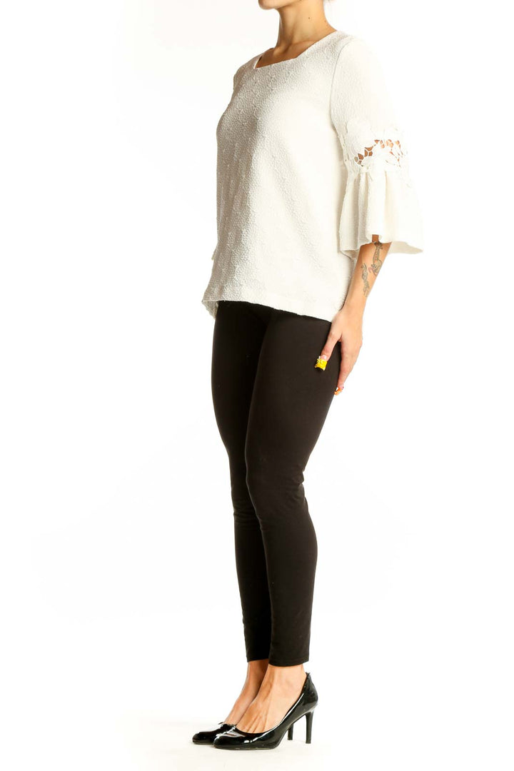 Front view of white Calvin Klein blouse with textured fabric and bell sleeves