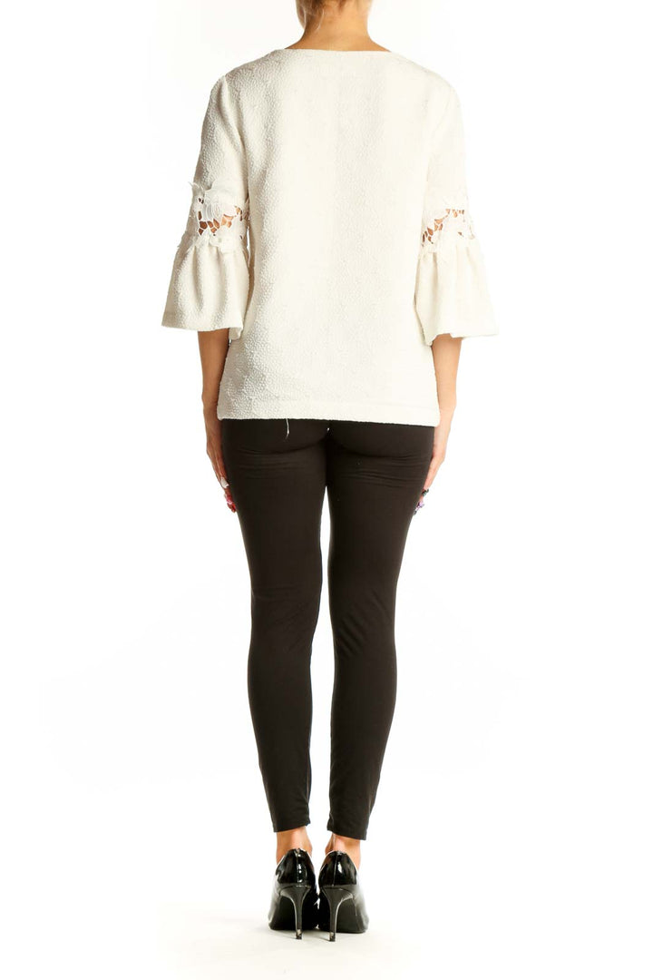 Side view of white Calvin Klein blouse showing bell sleeve detail and fit