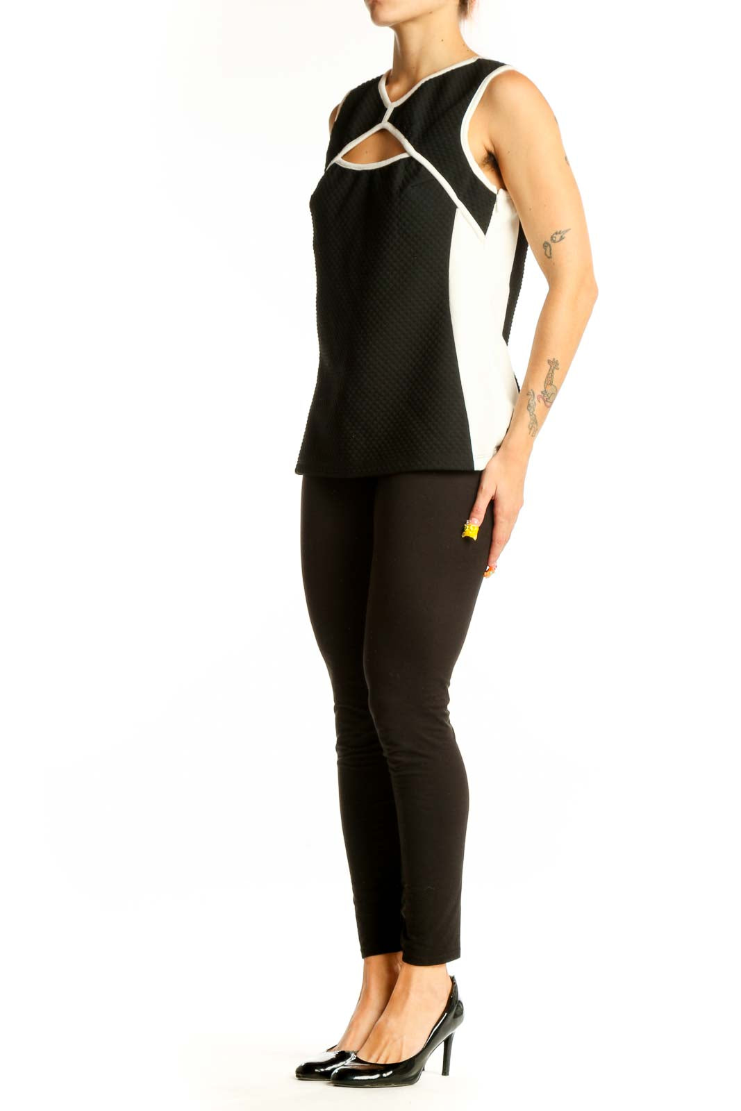 Front view of Bailey 44 black sleeveless top with cutout design and white trim