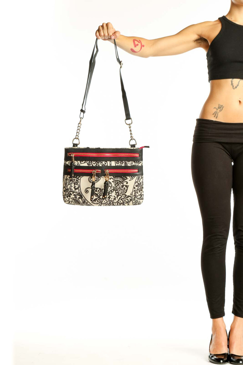 Front view of Spartina 449 black and white floral crossbody bag with red zipper accents