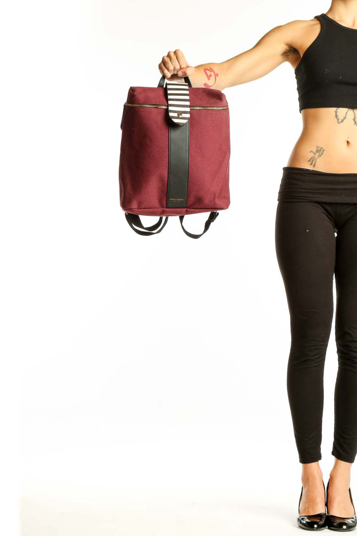 Front view of burgundy Henry Bendel canvas backpack with striped handle