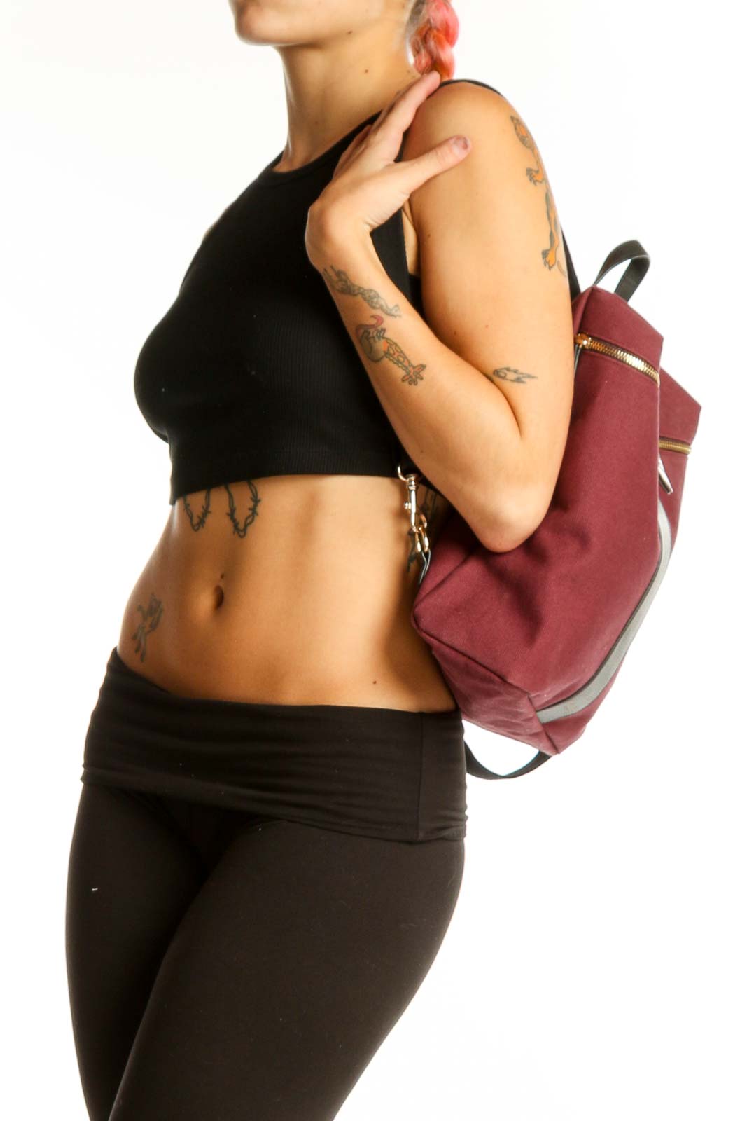 Front view of burgundy Henry Bendel canvas backpack with striped handle