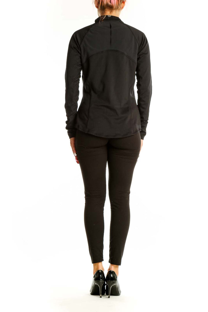 Side view of black Athleta half-zip performance top showing form-fitting silhouette