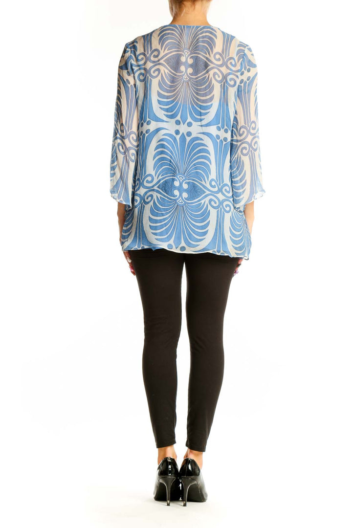 Side view of model wearing SilkRoll blue floral print sheer tunic with black pants