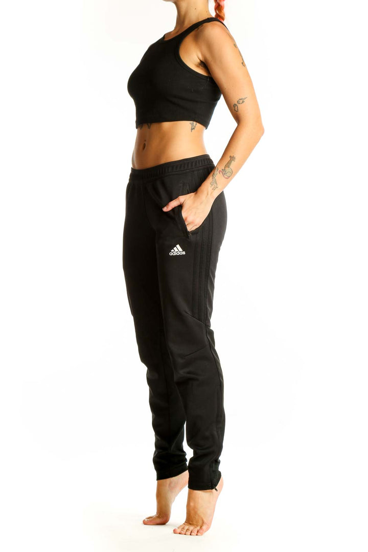Front view of black Adidas athletic pants on woman